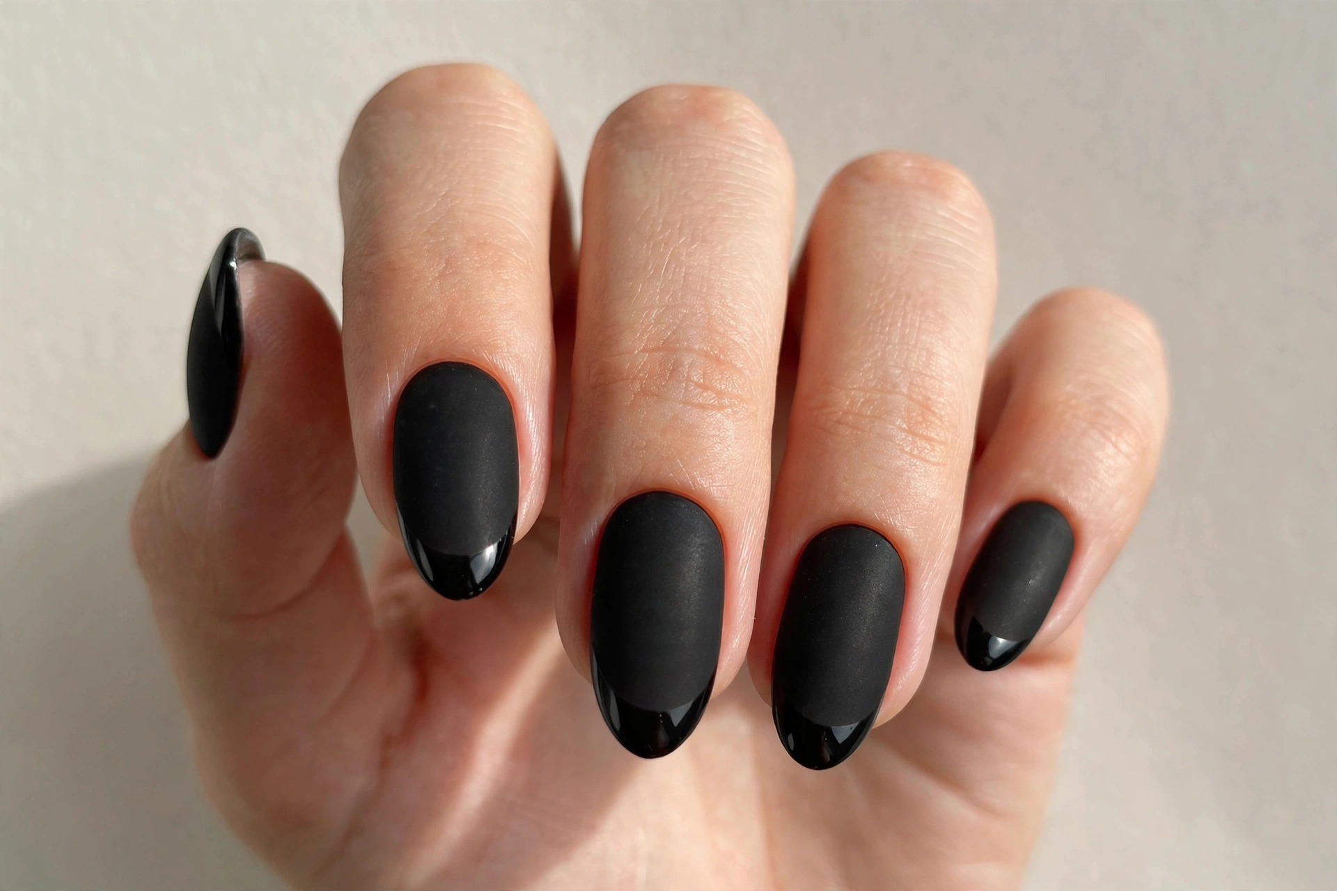 Matte black almond nails with glossy black tips