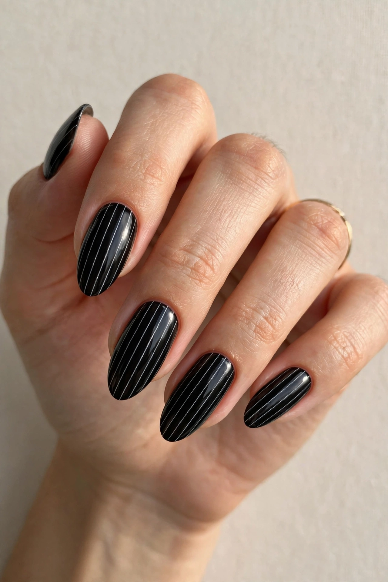 Glossy black nails with thin white pinstripe lines