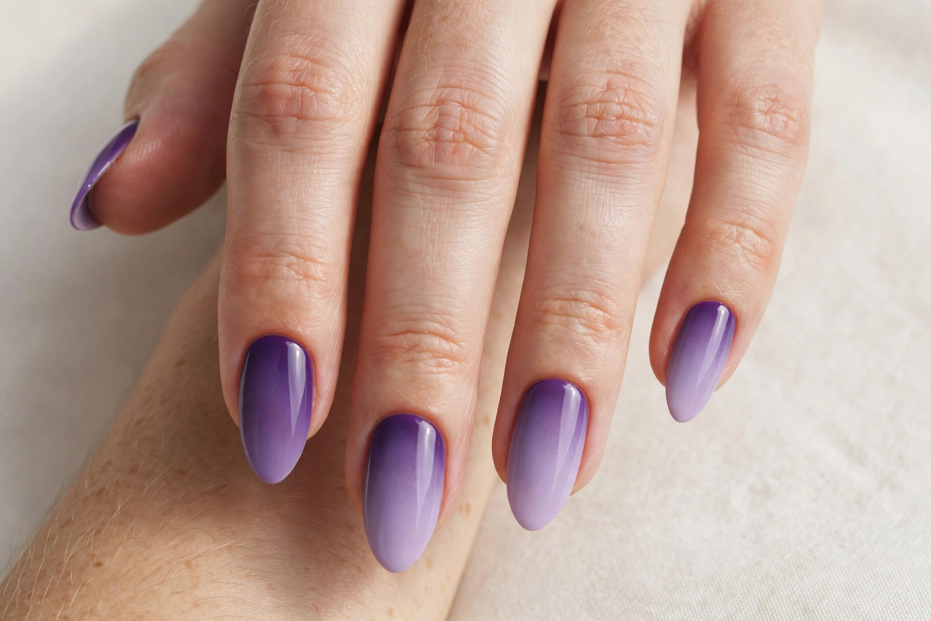 Lavender ombre fade manicure blending deep purple into pale lilac