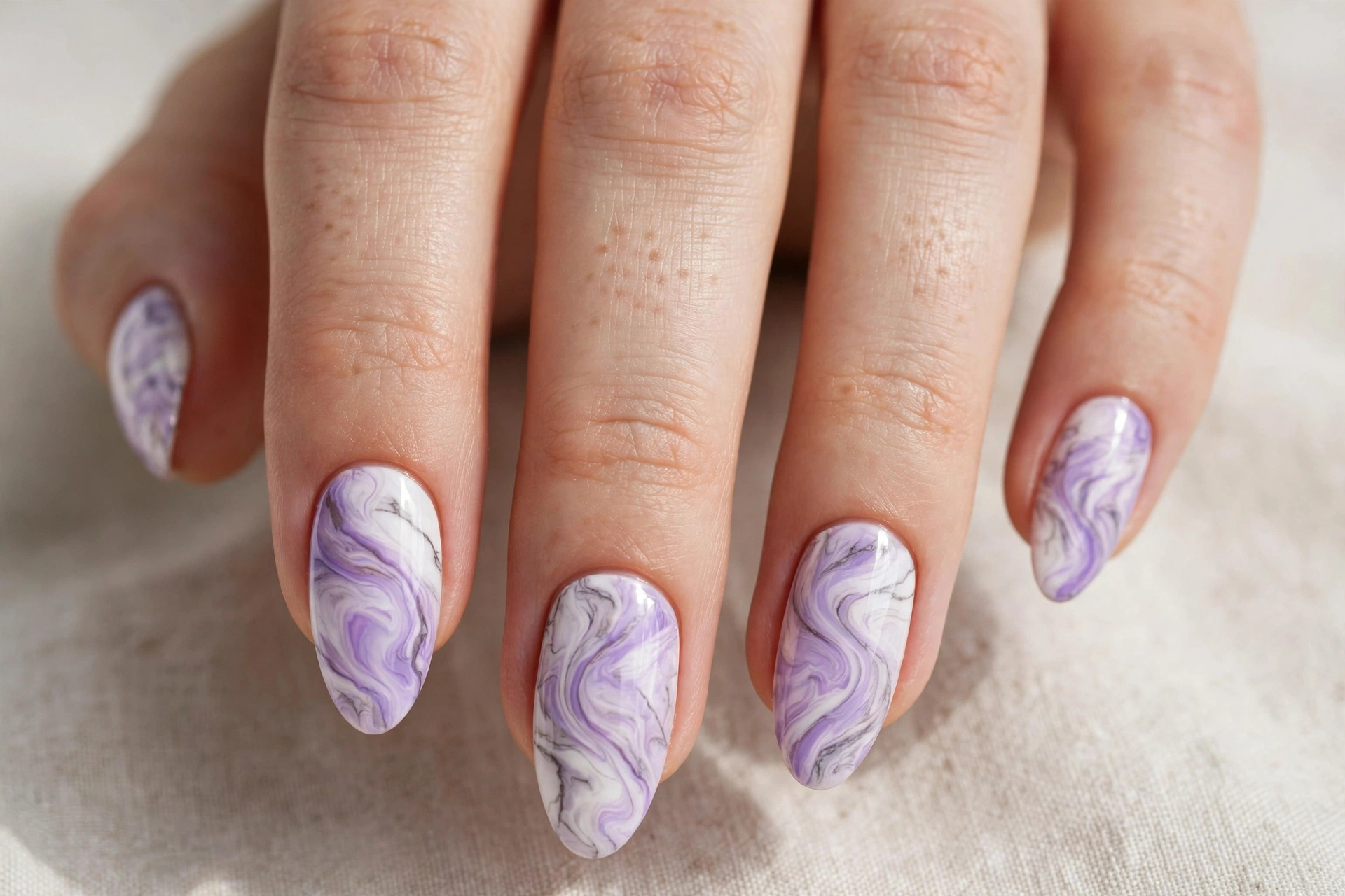 Lavender and white marble swirl nail art with elegant stone veining