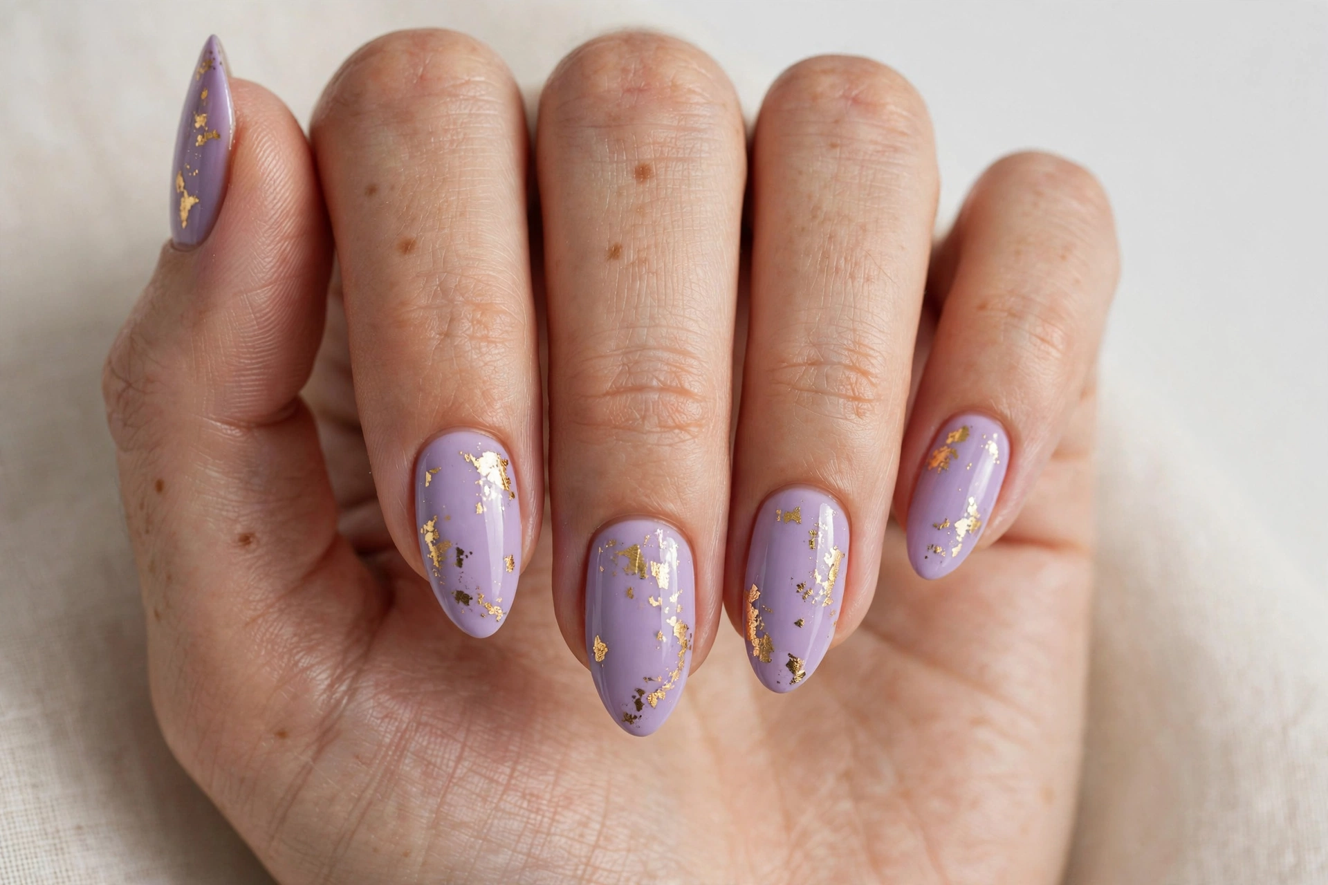 Lavender nails with delicate gold foil flake accents