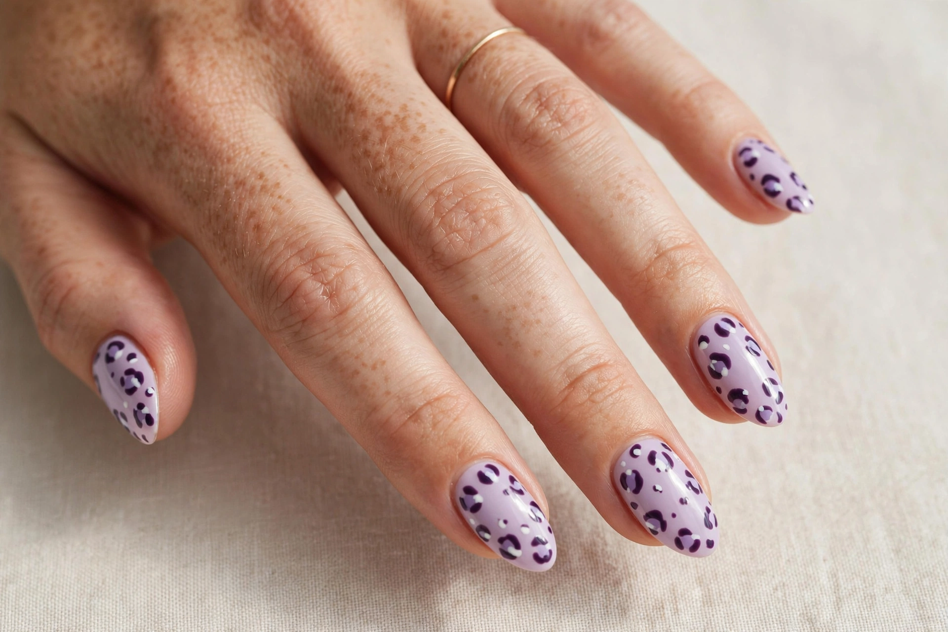 Lavender nails with subtle leopard print pattern in deep purple and white
