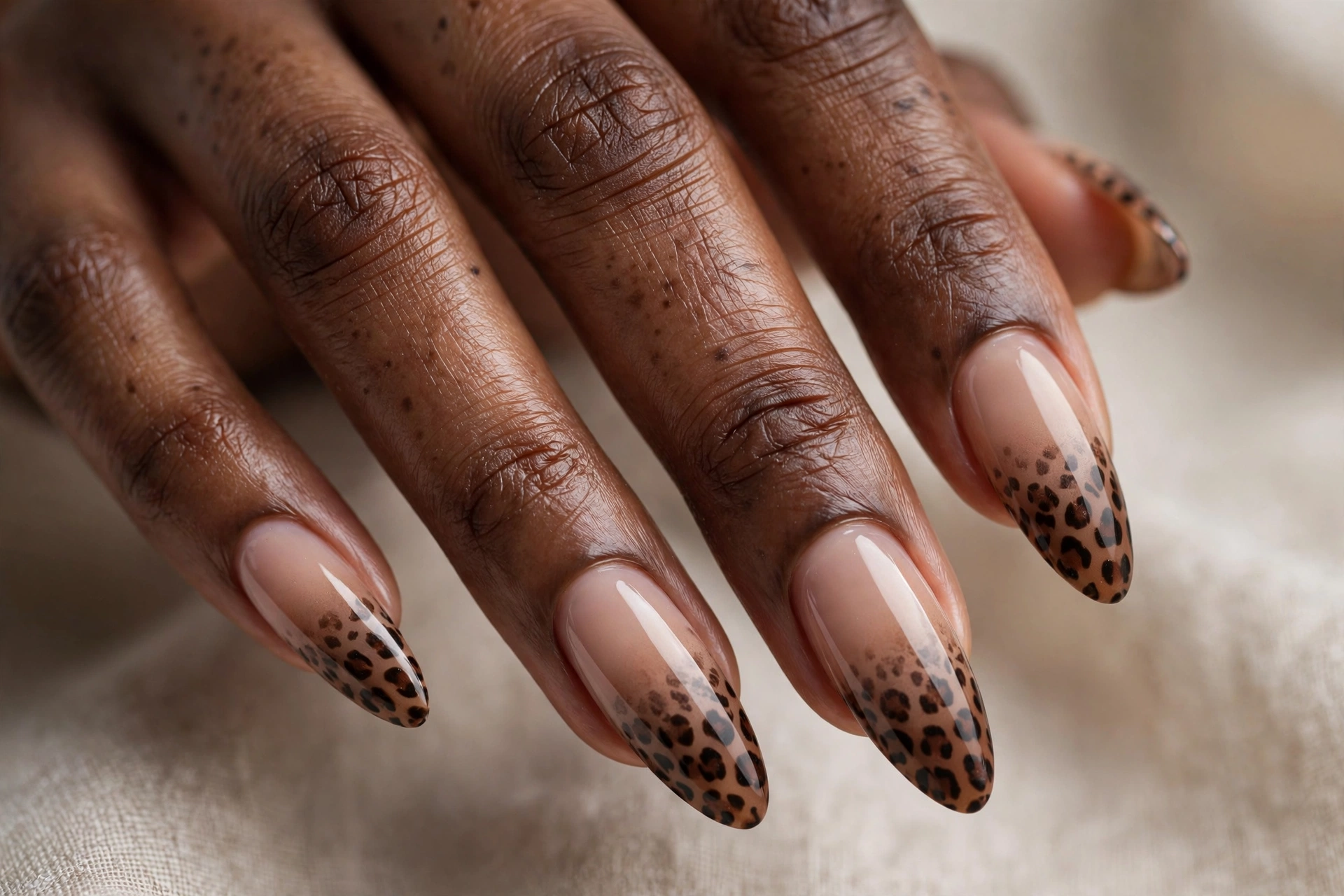 Leopard print fading over a nude to brown ombre on long almond nails