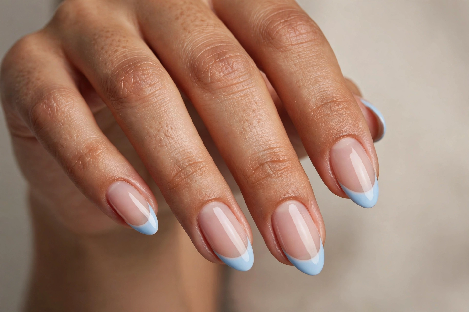 Baby blue French tip nails with sheer nude base on almond nails