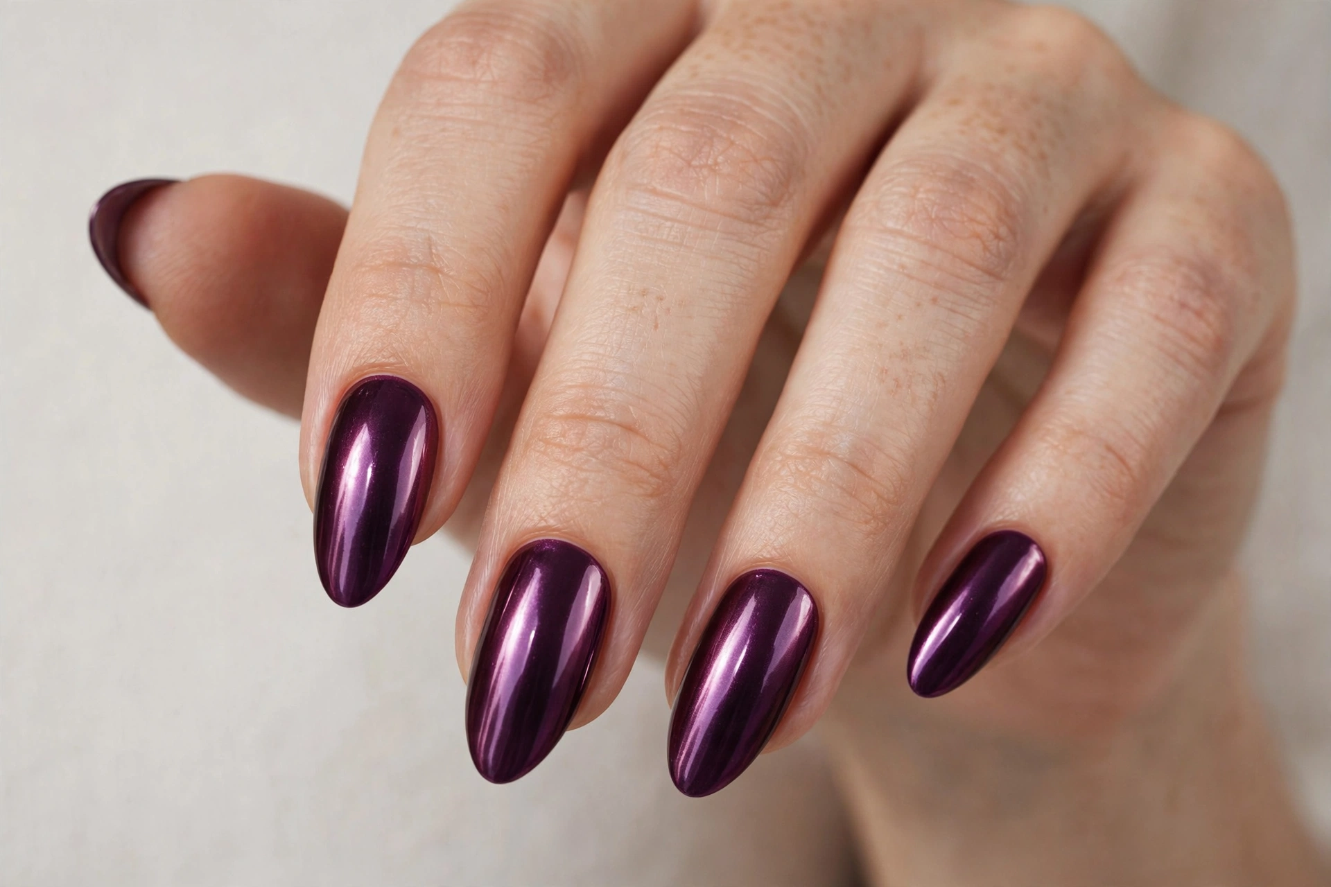 Deep plum chrome metallic manicure on long almond shaped nails