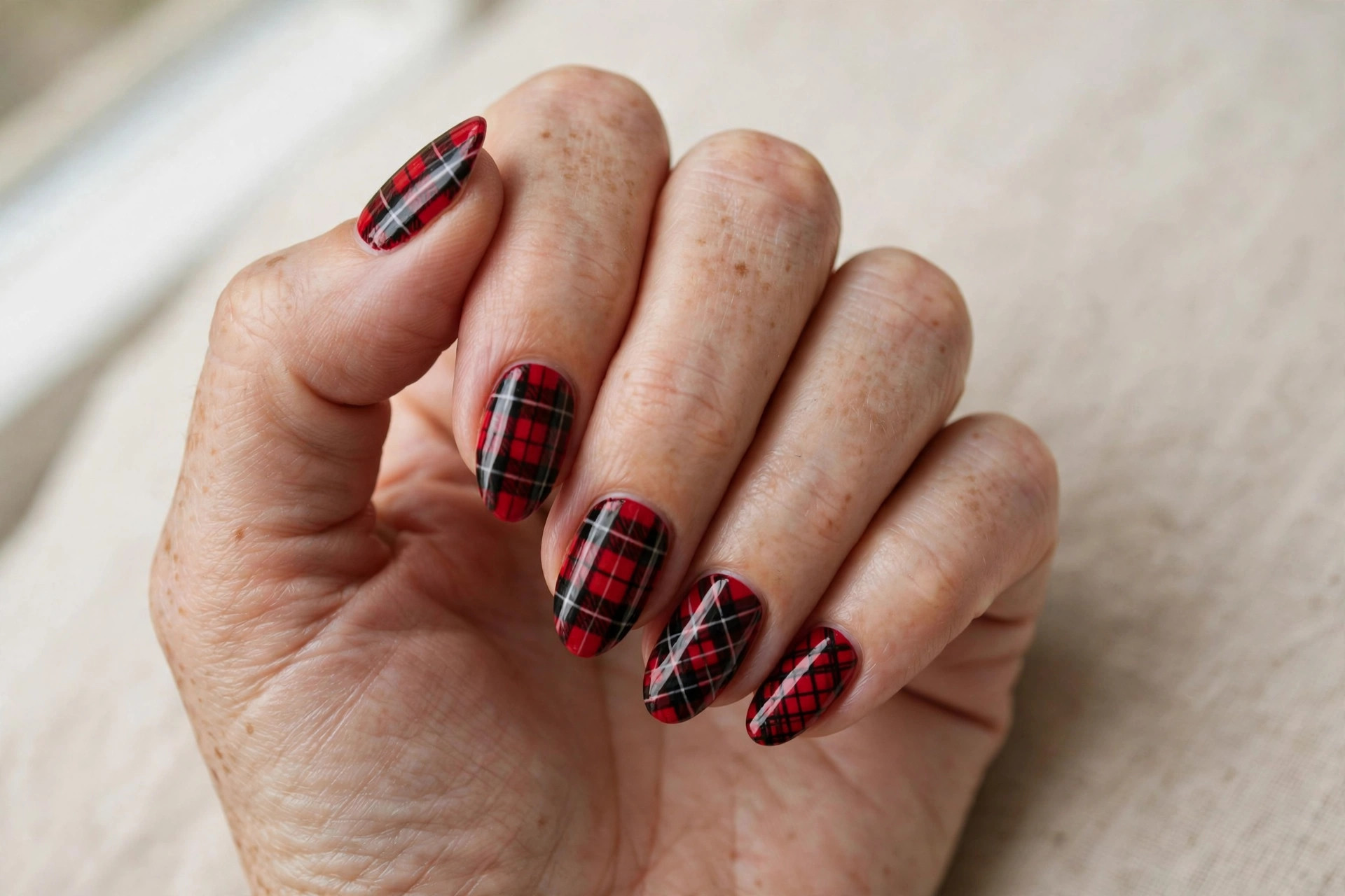 Red and black tartan plaid pattern manicure in festive style