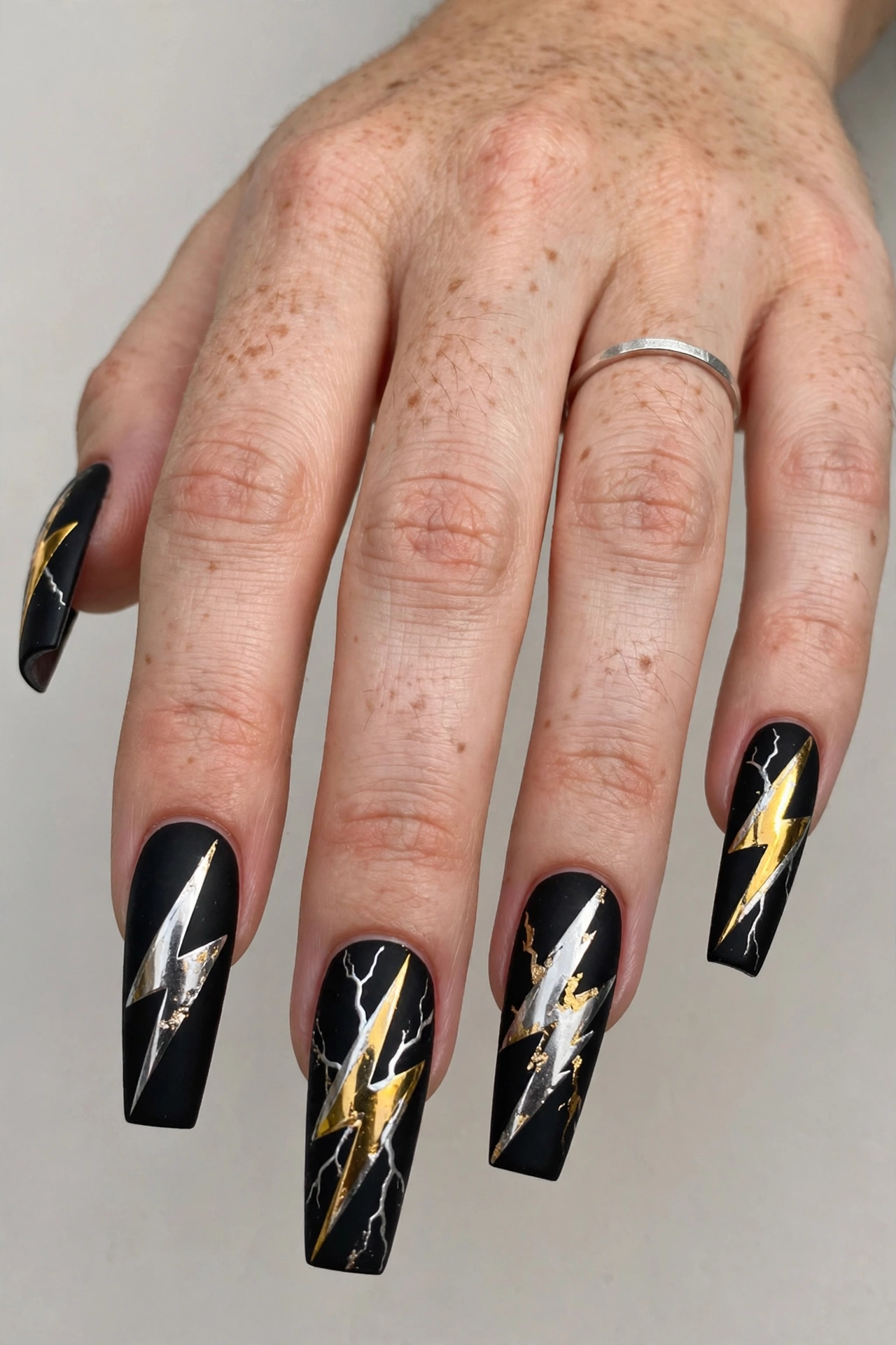 Black lightning bolt rock festival nails with metallic silver and gold