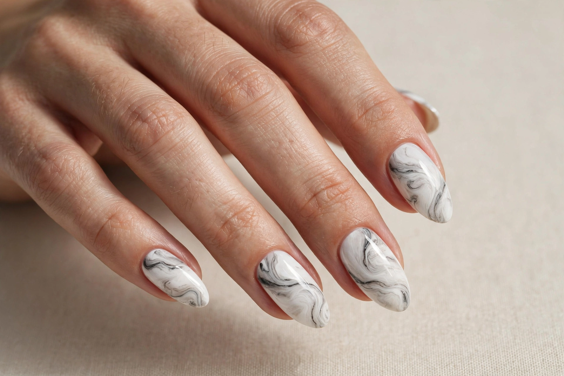 Deep red manicure with delicate gold foil accents on almond-shaped nails