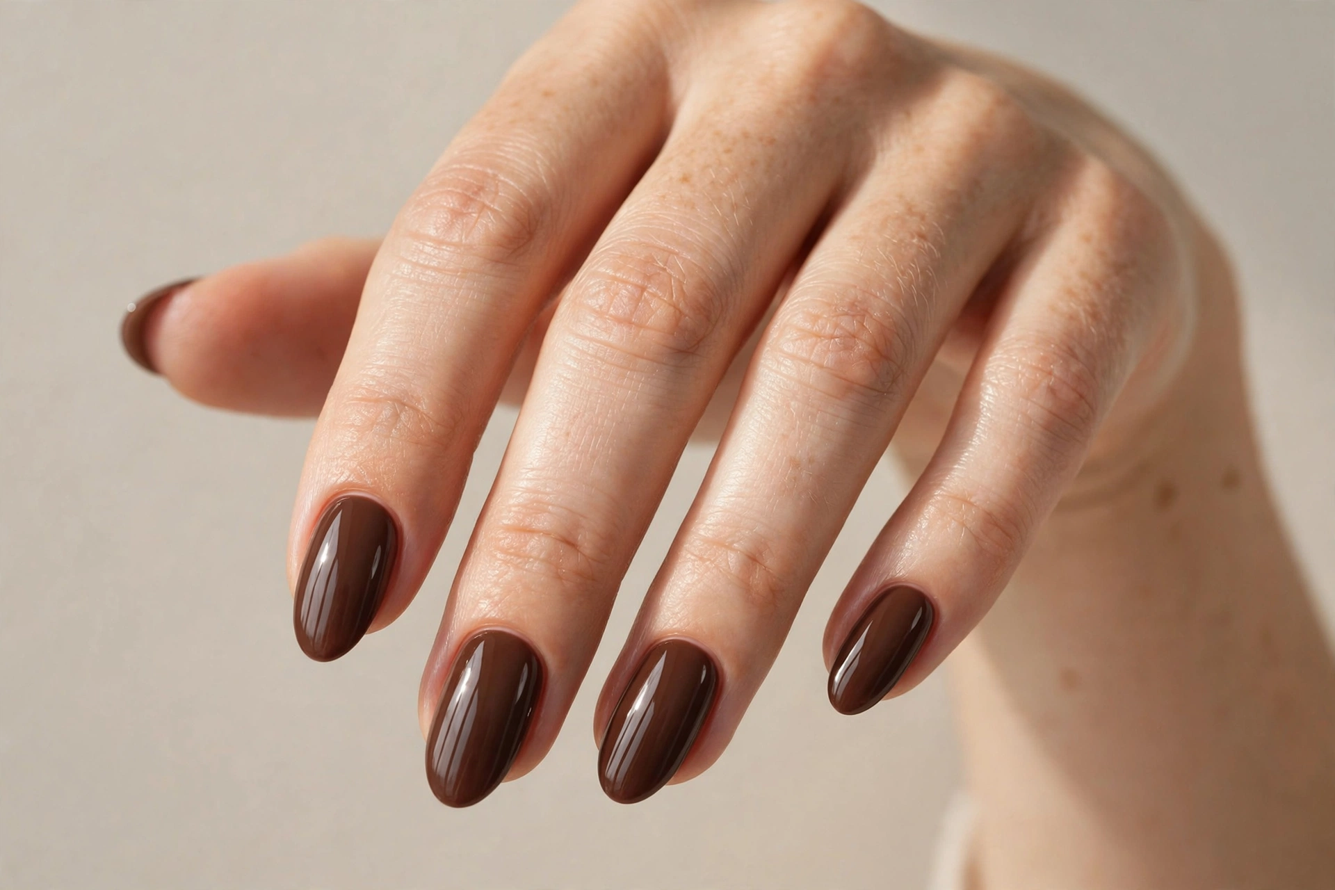 Chocolate brown glossy manicure on almond nails