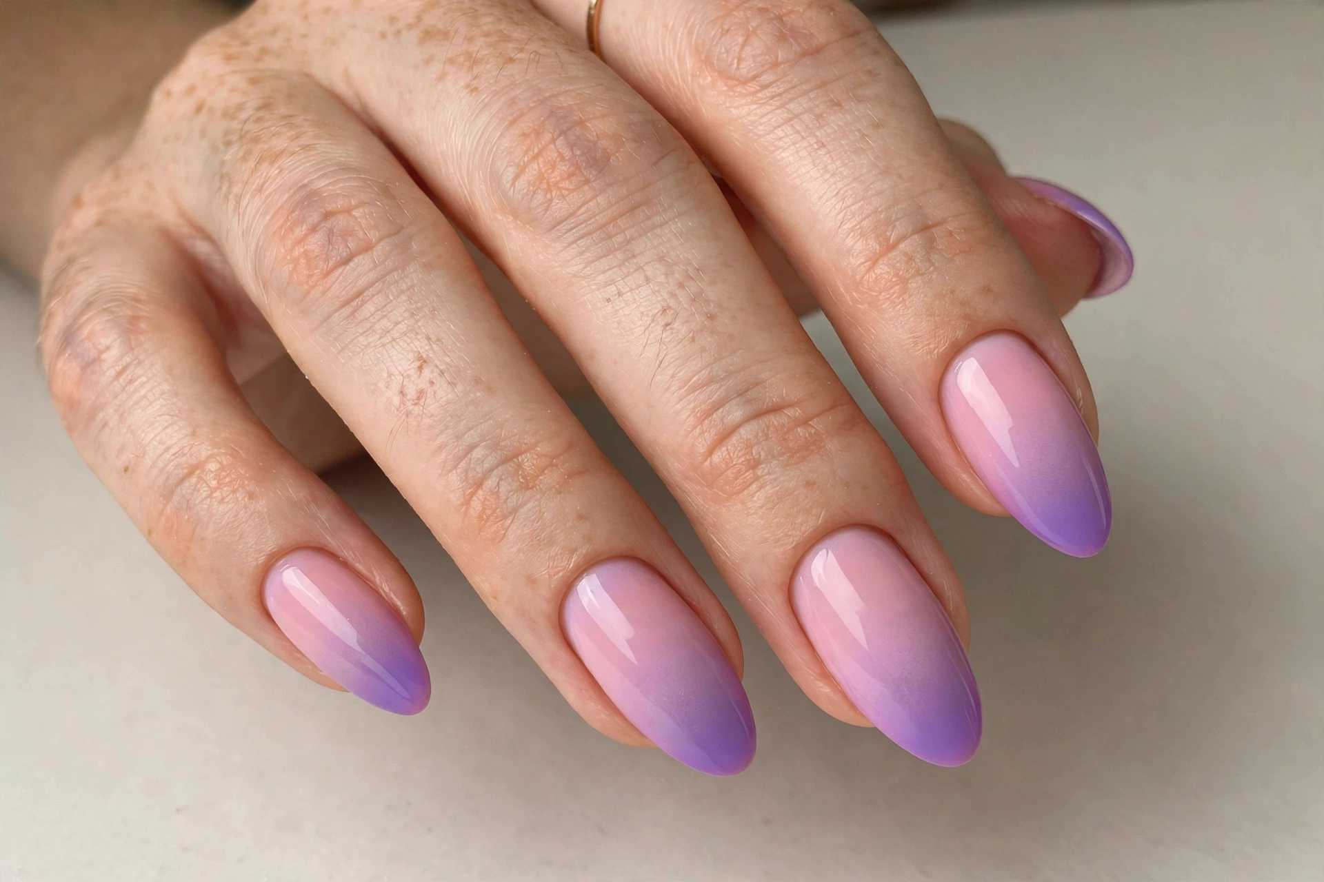Aura ombre nails blending pink and purple in a soft airbrushed gradient