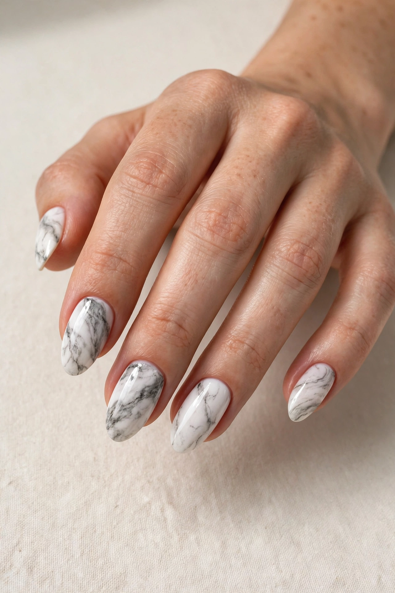 Elegant white and gray marble nail art on almond-shaped nails