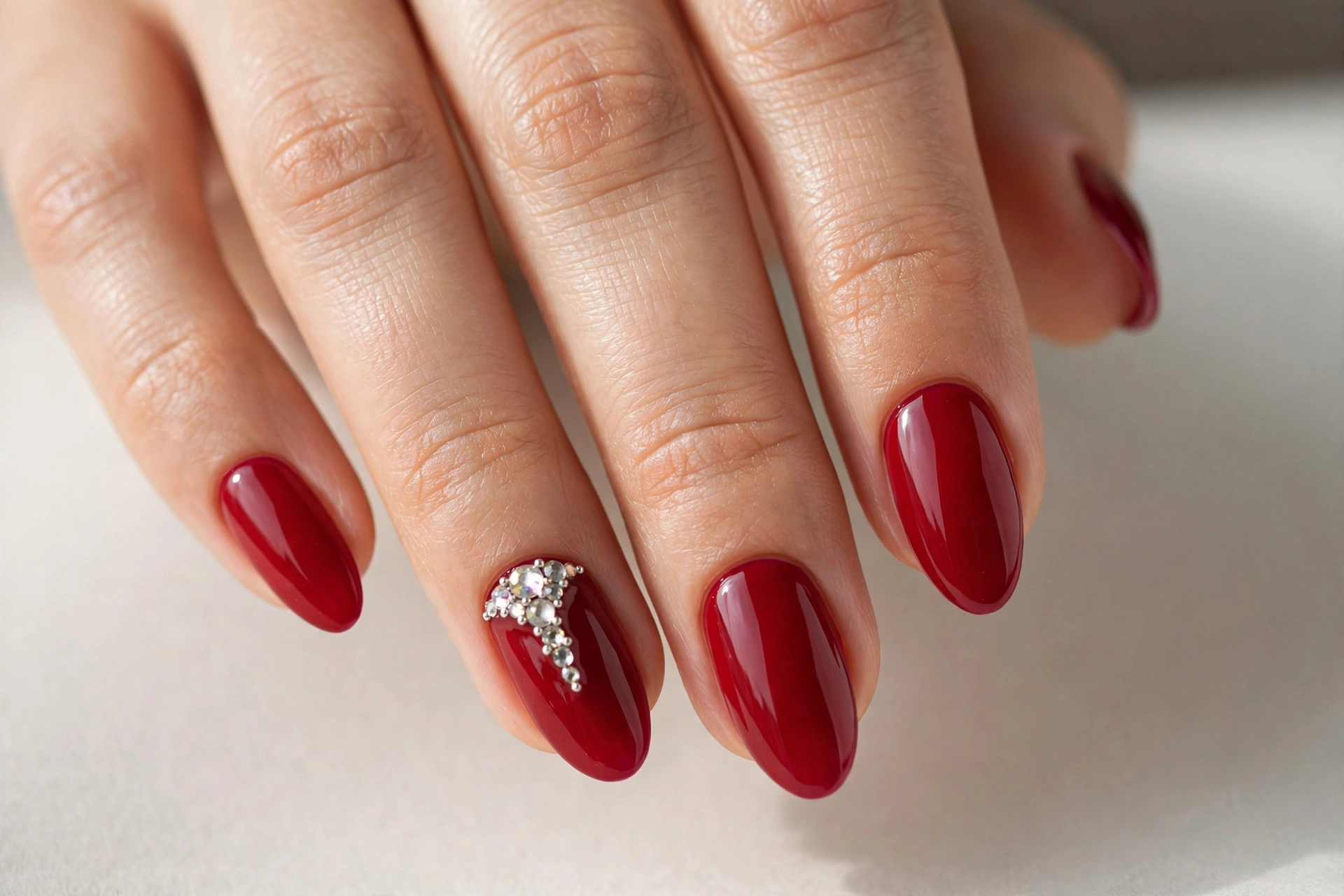 Ruby red Christmas nails with rhinestone accents