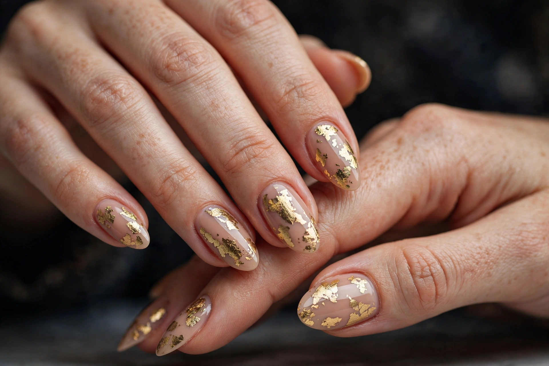 Irregular antique gold leaf flakes on glossy nude nails