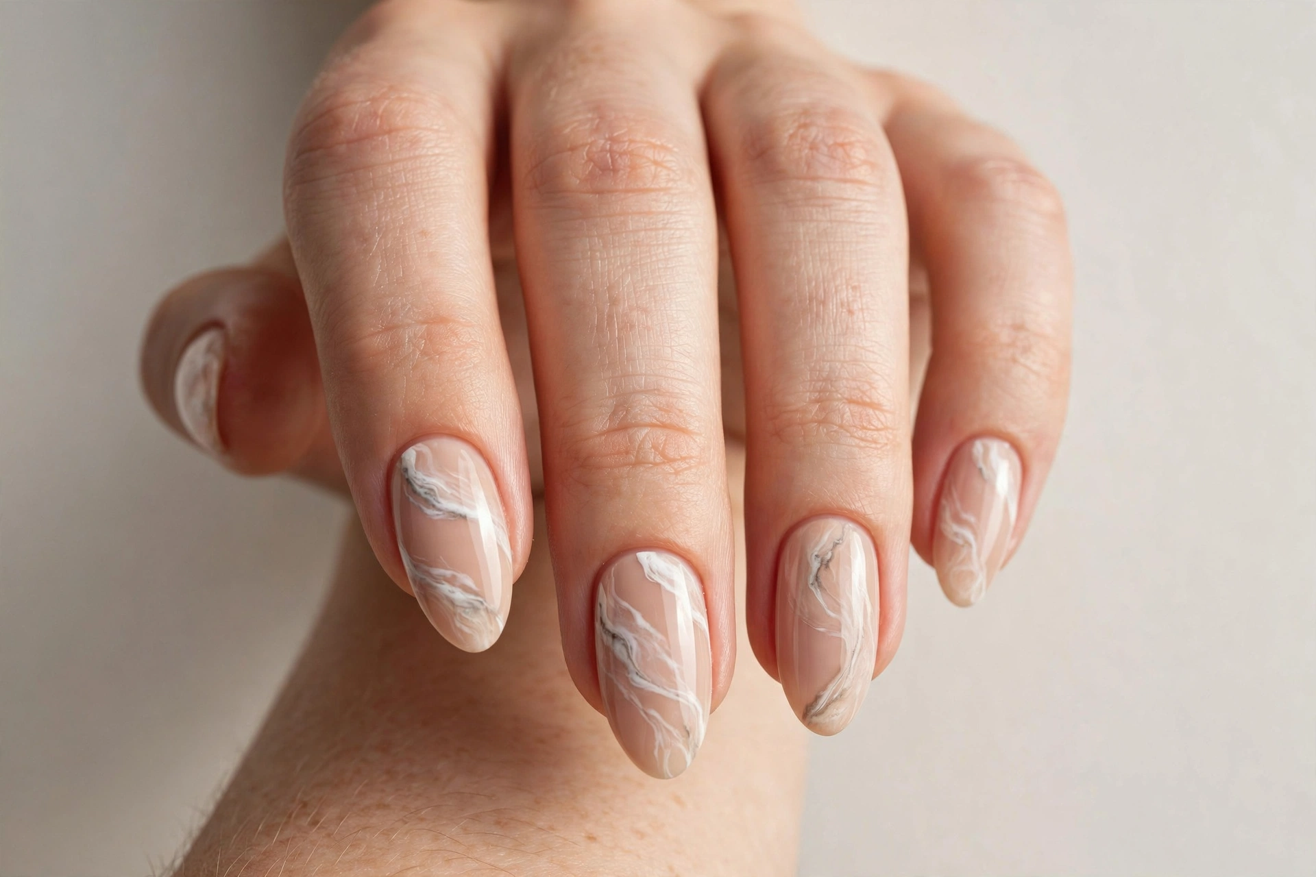 Nude and white marble nail art on almond nails