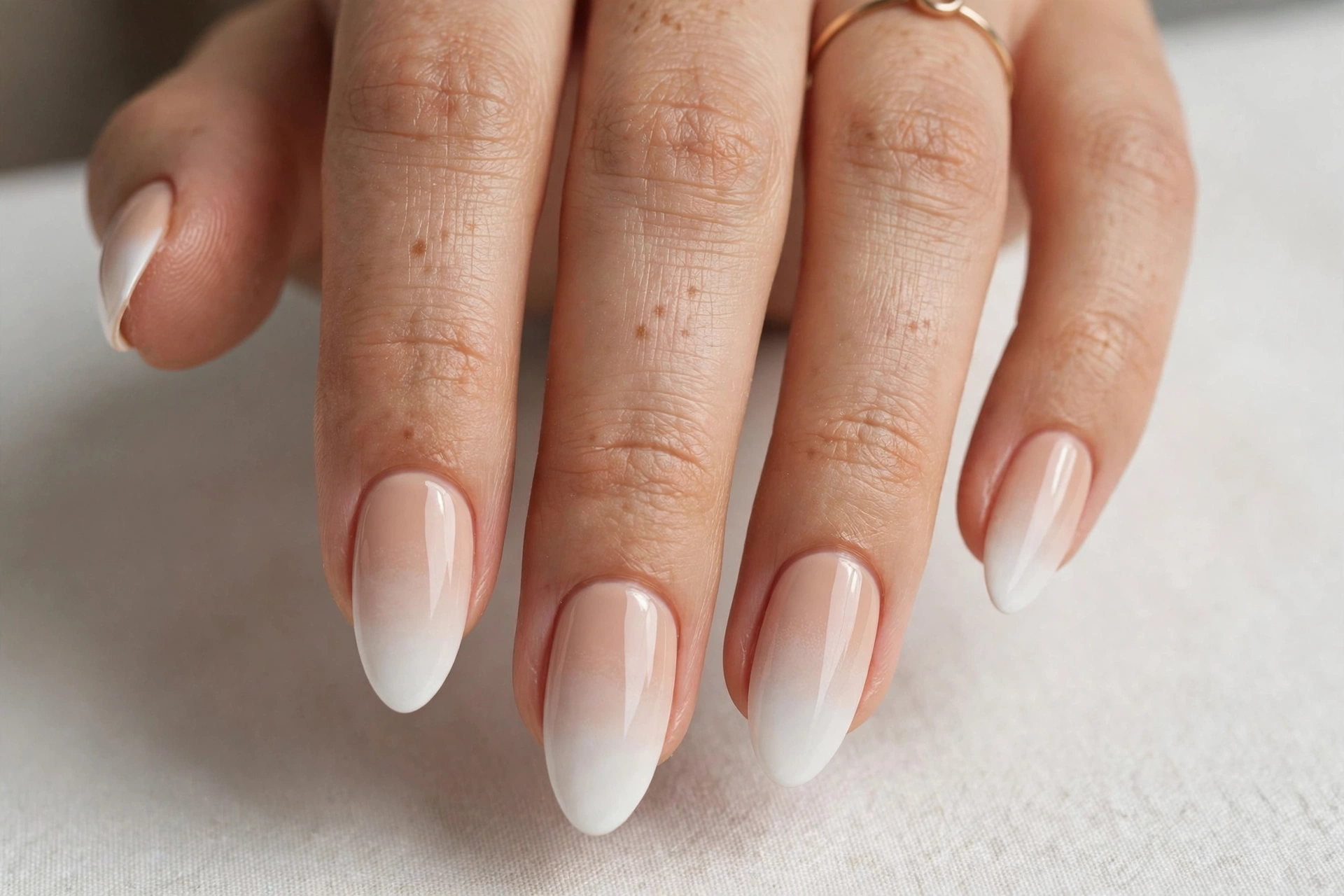 Classic nude-to-white baby boomer ombre manicure on almond nails