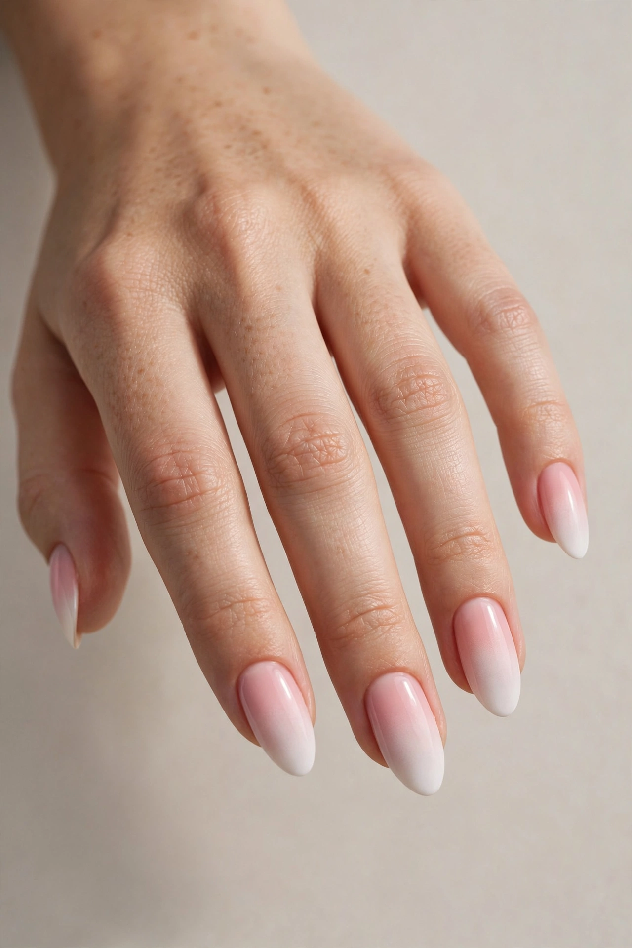 Soft pink-to-white ombre gradient manicure on almond shaped nails