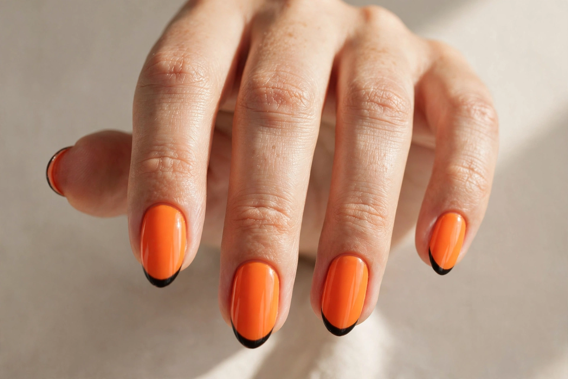 Tangerine orange nails with thin black french tips