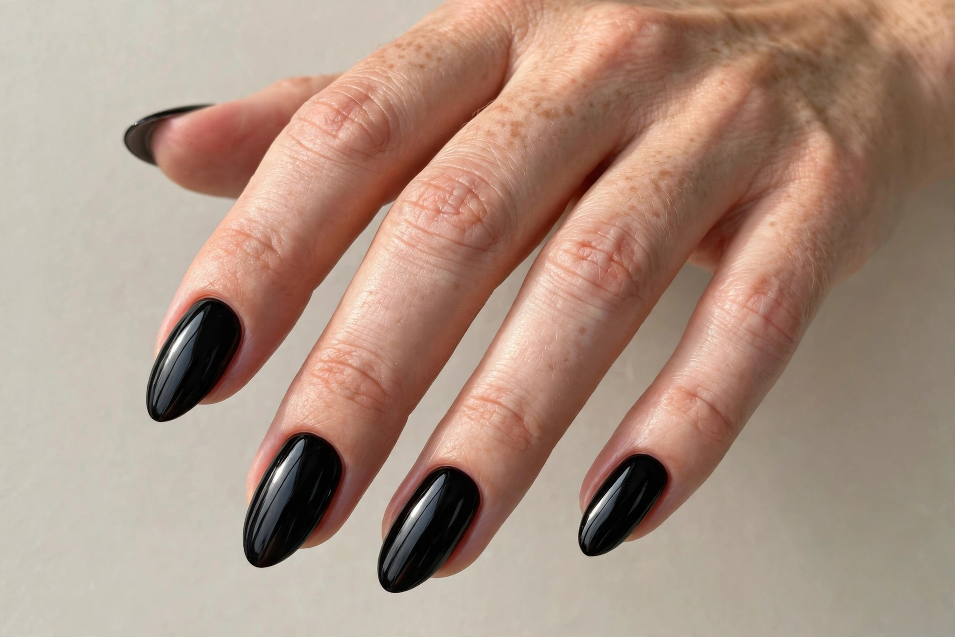 Close-up of glossy jet black manicure on oval shaped nails