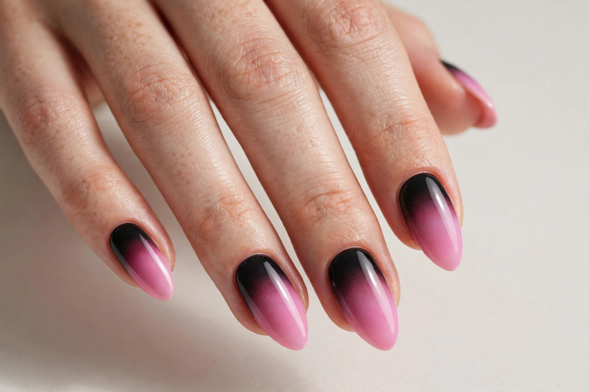 Almond nails with pink and black ombre gradient fading from pink to black