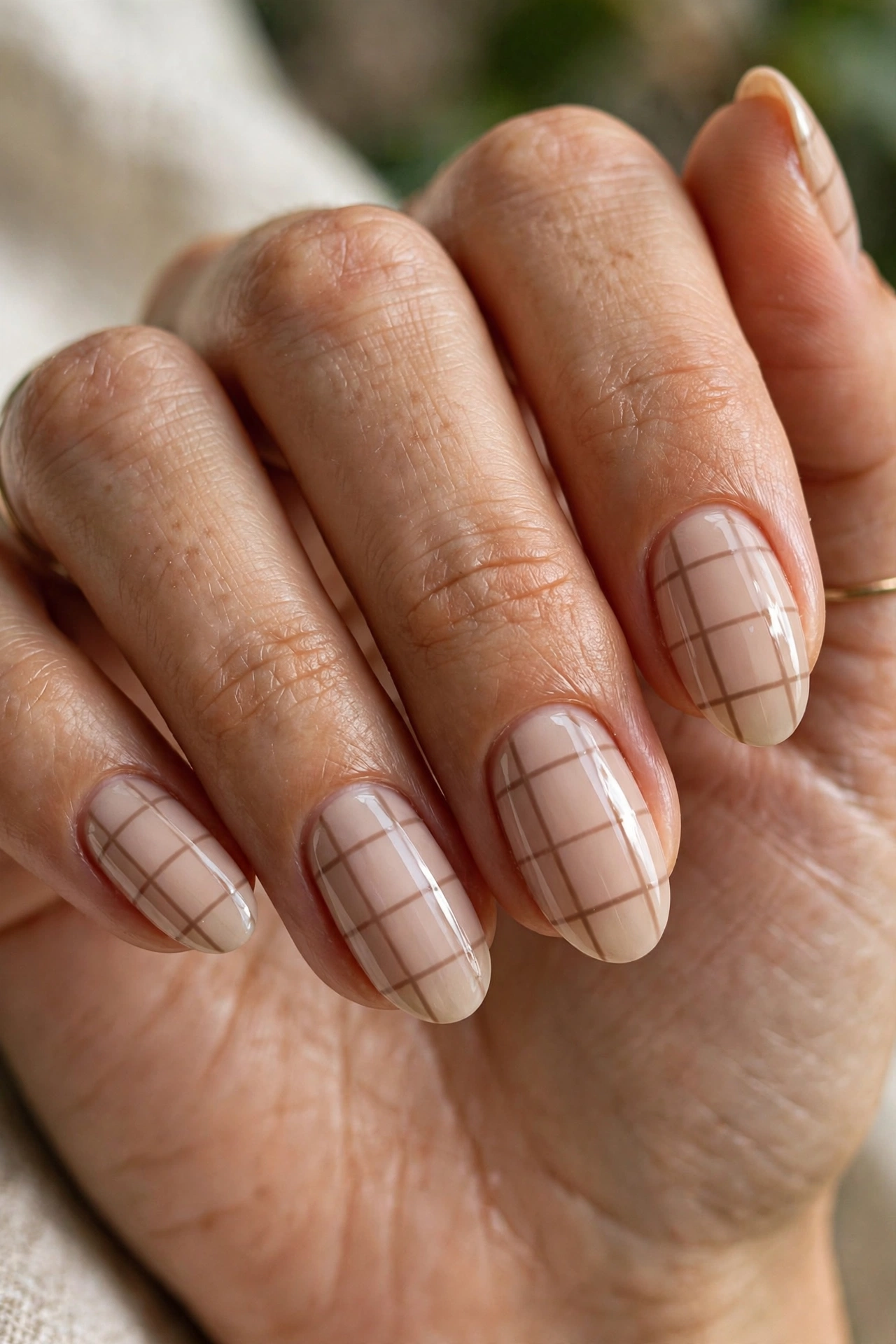 Oval shaped nails with beige windowpane check nail art