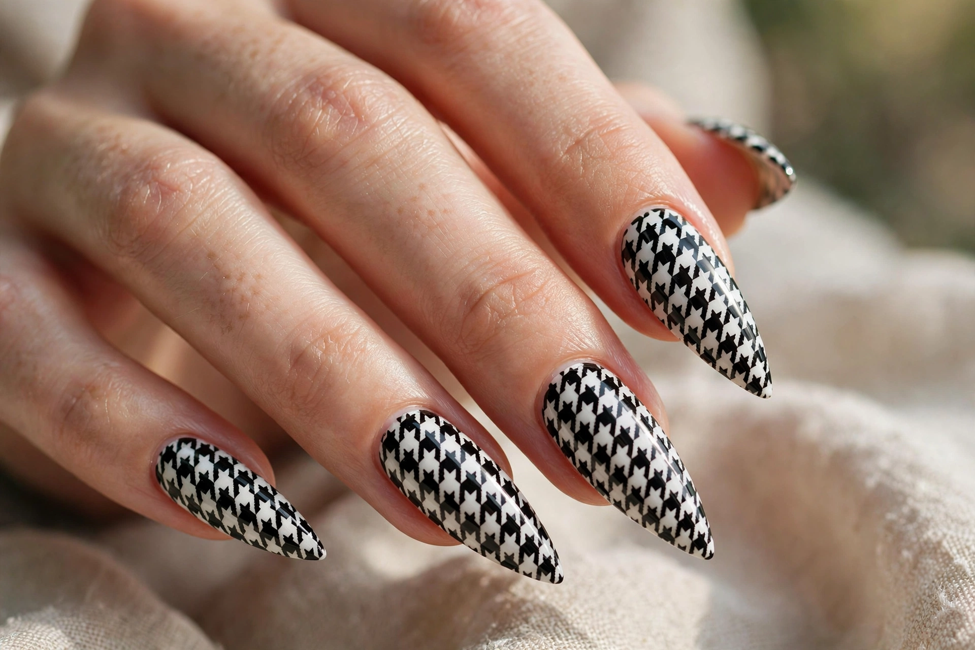 Stiletto shaped nails with black and white houndstooth nail art