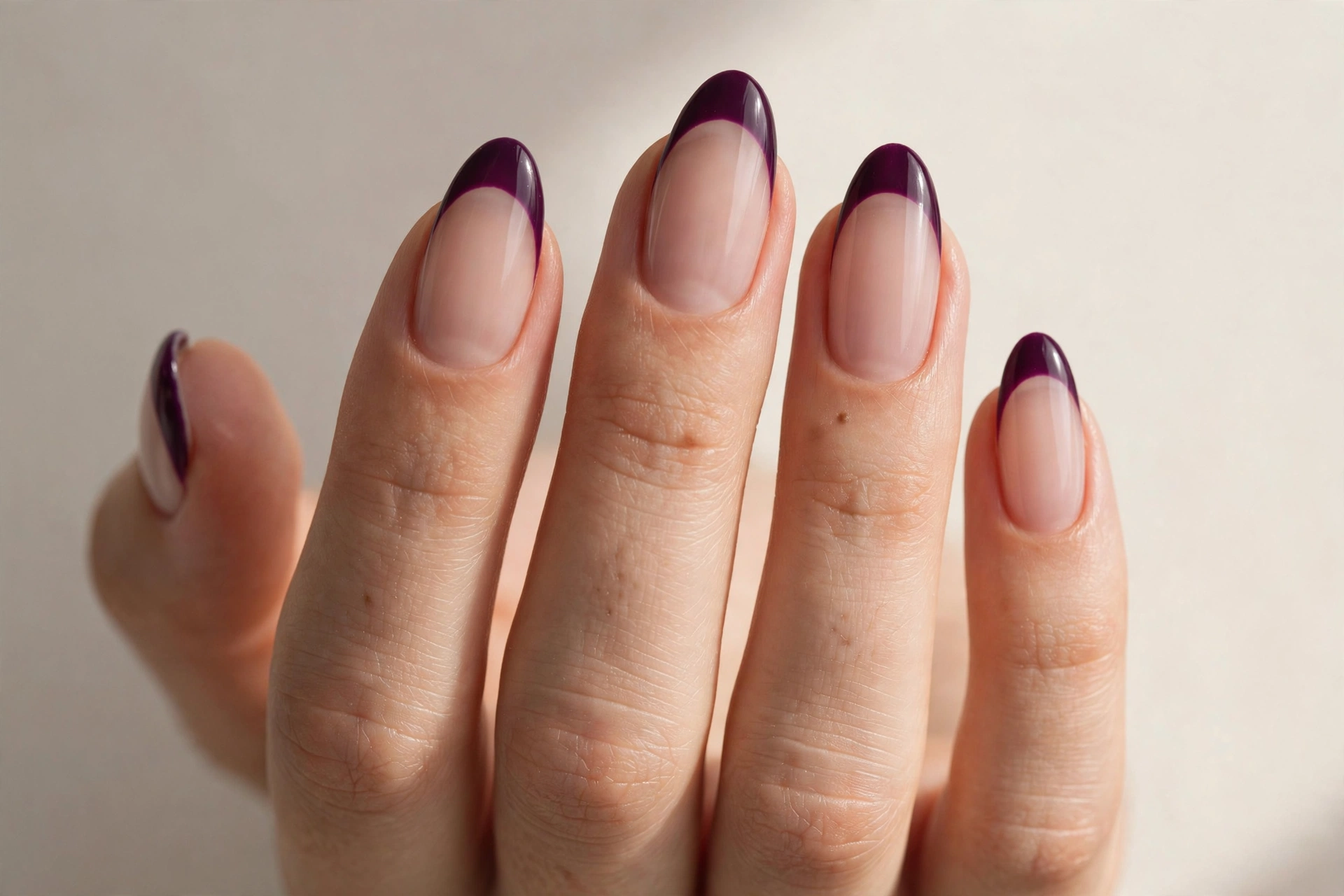 Plum purple french tip manicure on sheer nude base