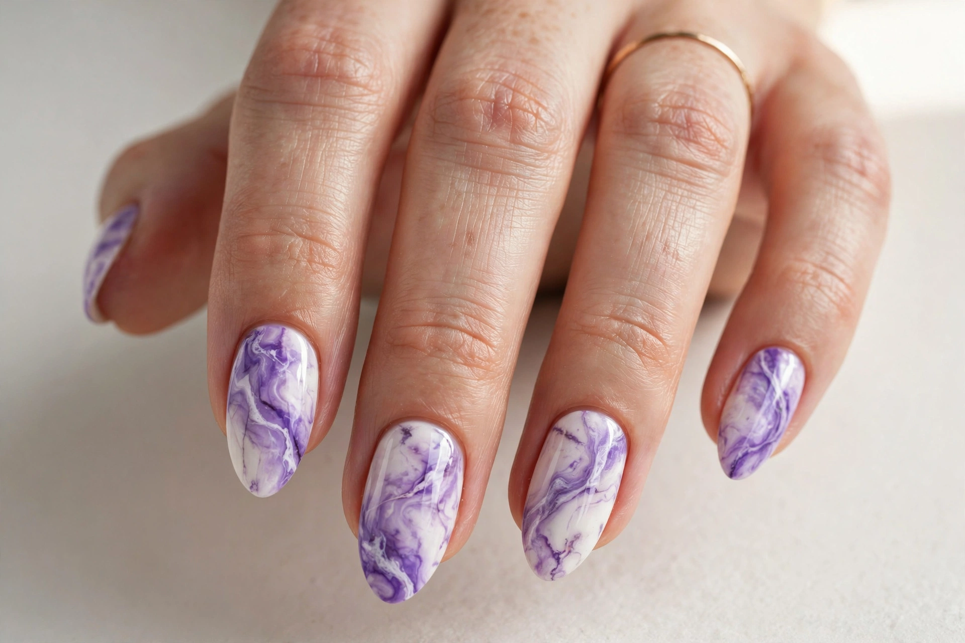 Violet and white marble nail art on almond-shaped nails