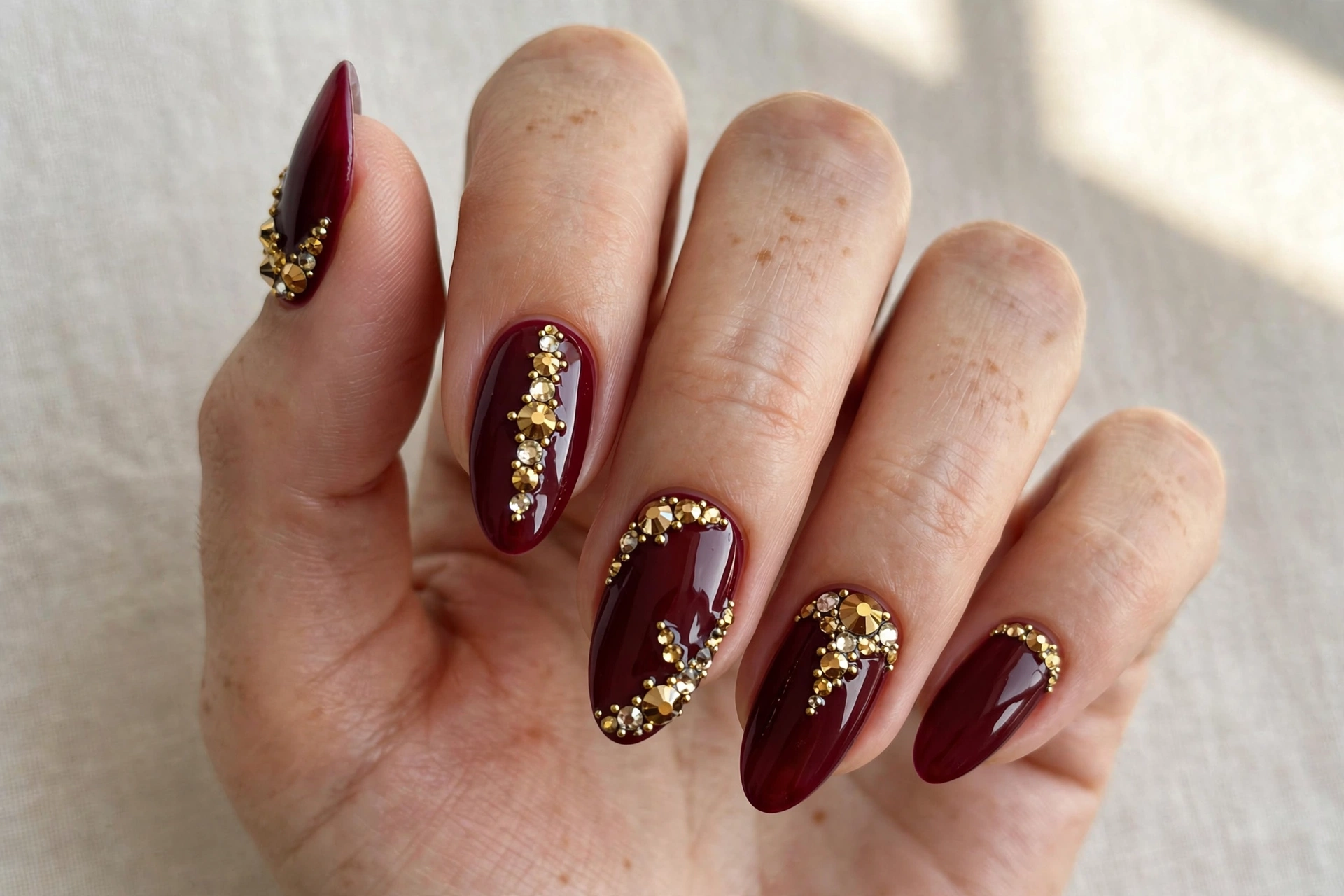 Burgundy nails with gold crystal rhinestones