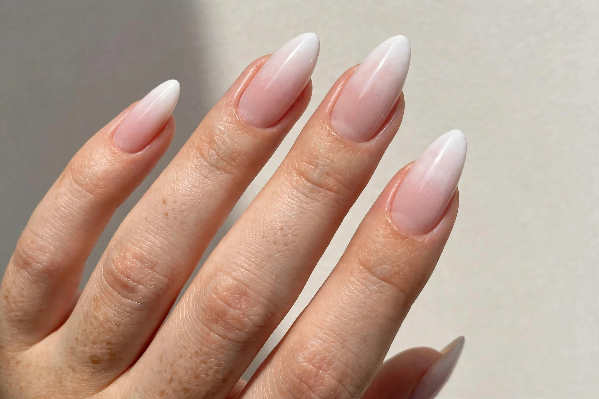 French fade baby boomer manicure blending white into pink on russian almond nails