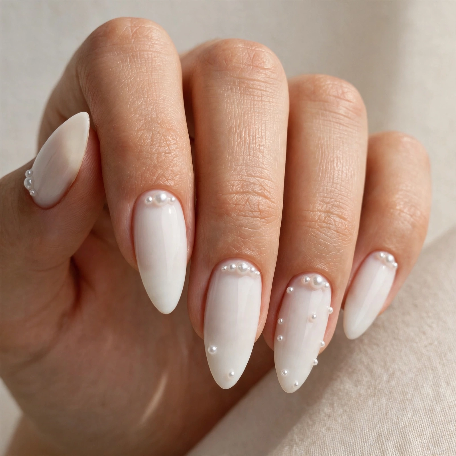 Milky white russian almond nails decorated with tiny pearl accents