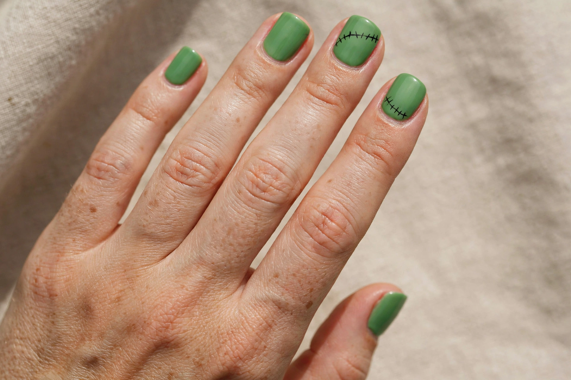 Frankenstein green nails with black stitch nail art