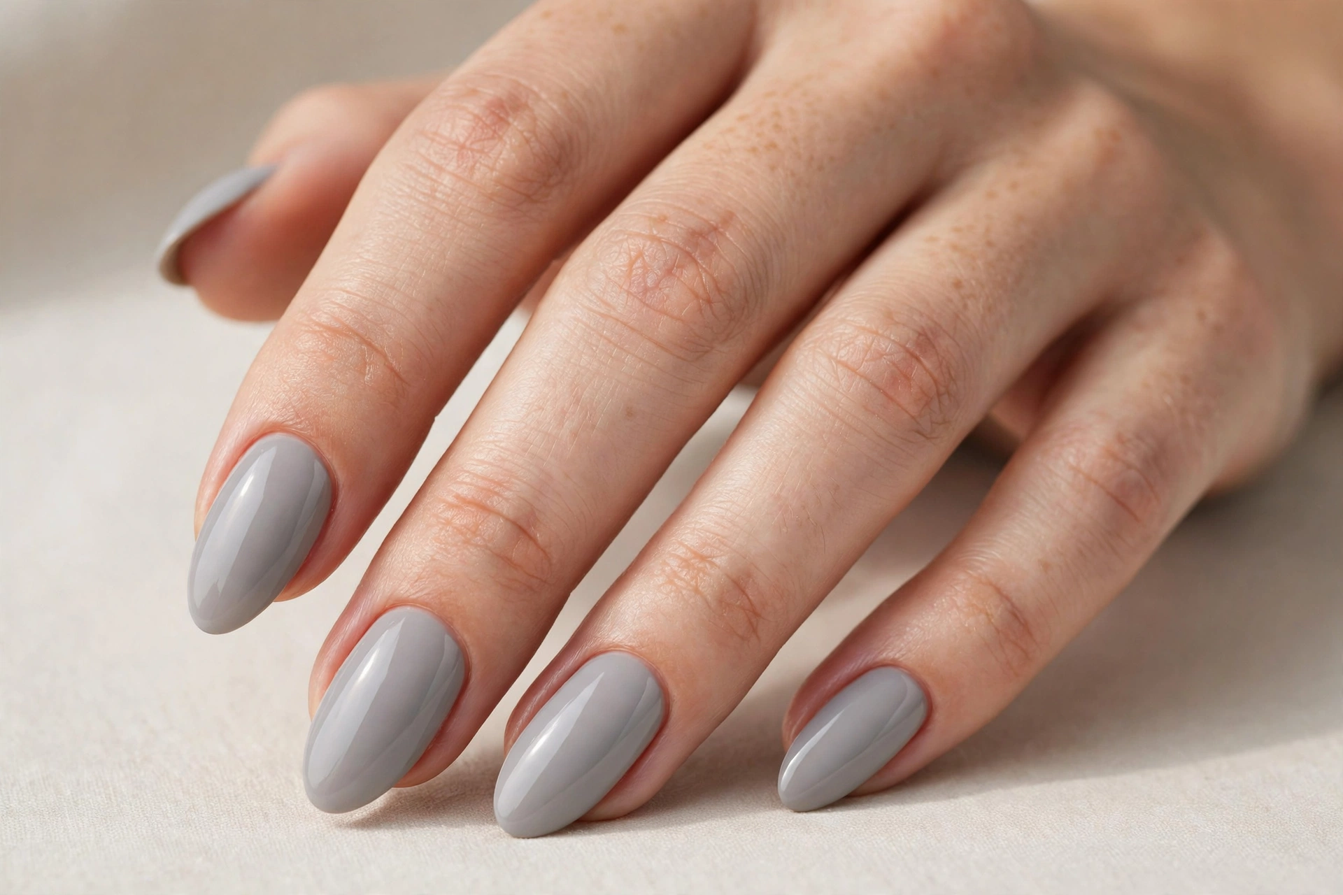 Close-up of almond shaped nails with soft dove gray manicure