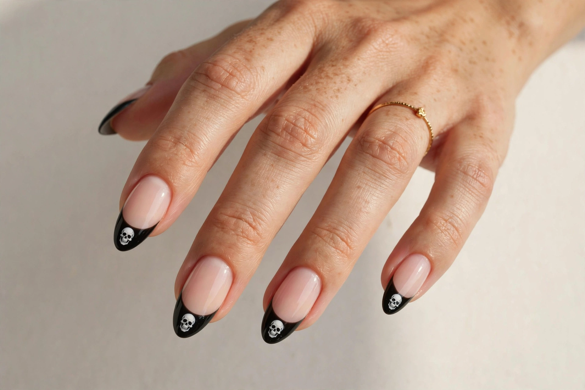 French tip nails with tiny skull art on the tips
