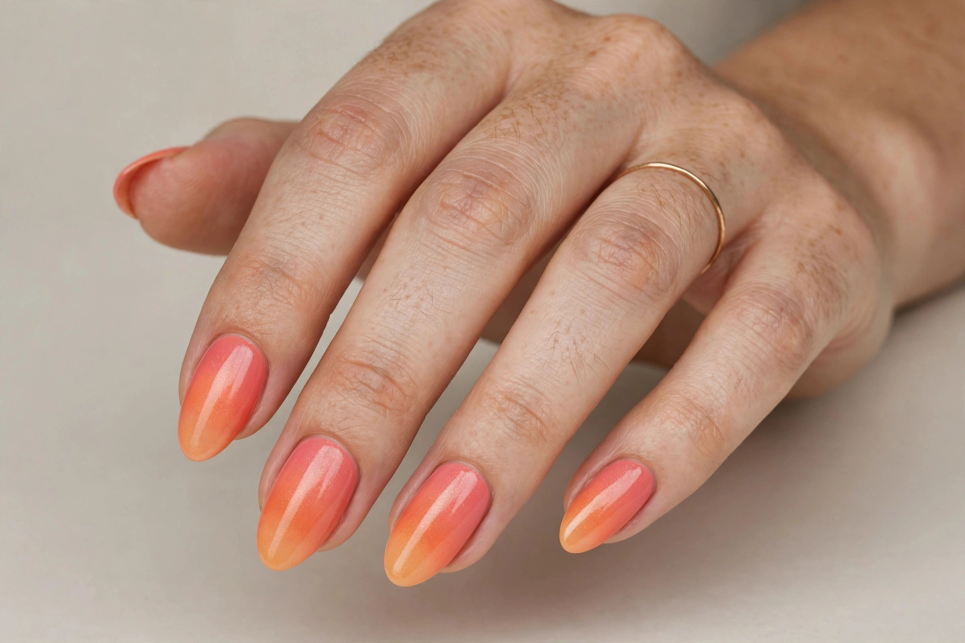 Coral sunset ombre nail design with pink-to-orange gradient