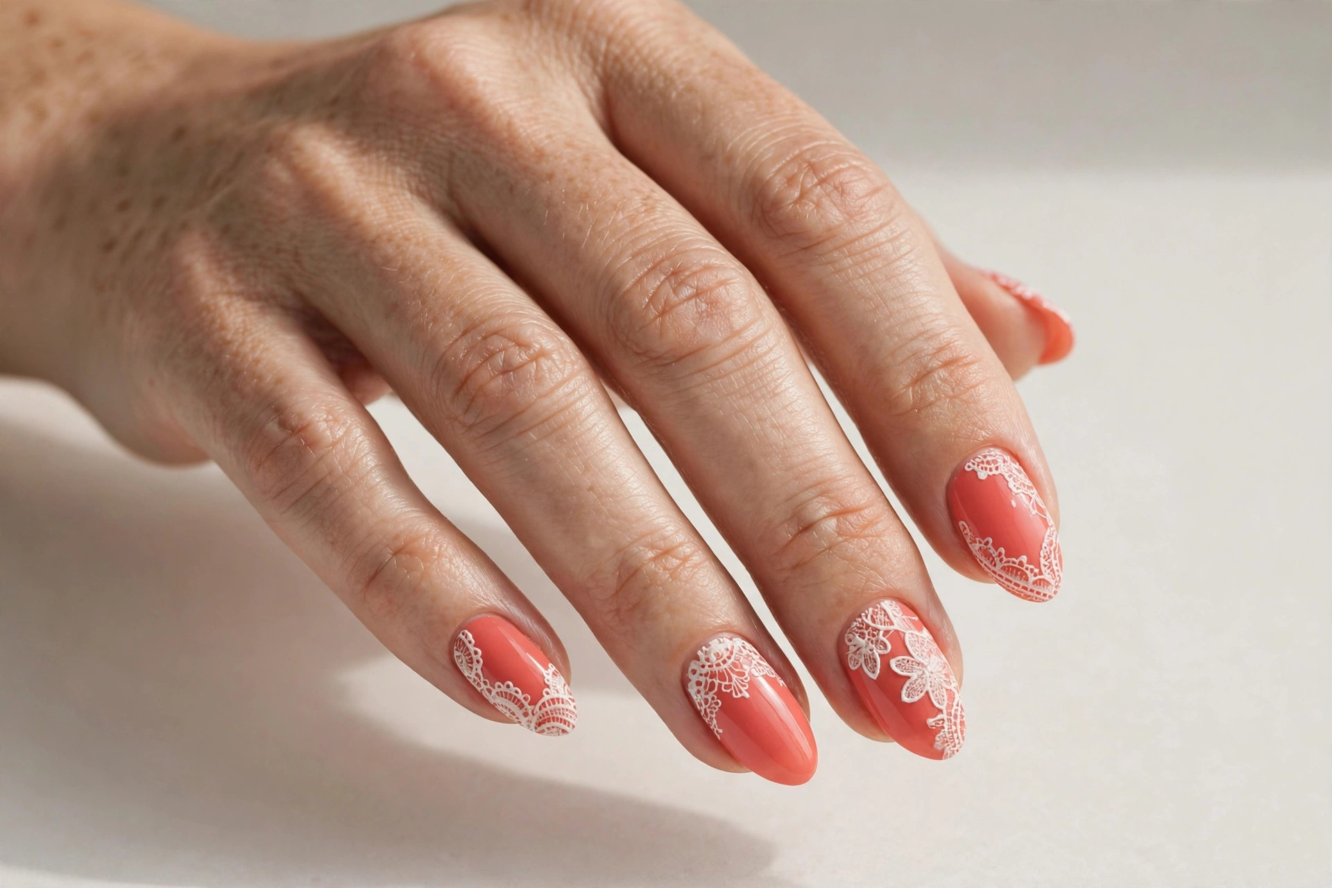 Coral nails with white lace detail nail art