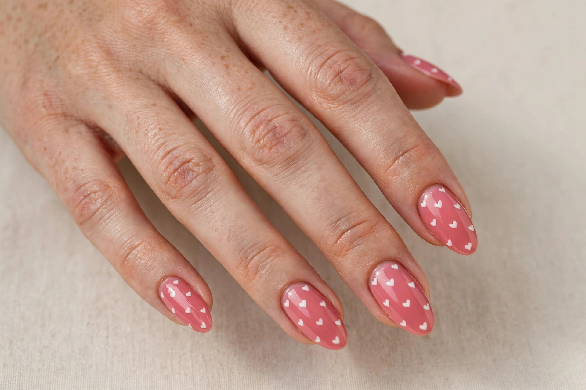 Strawberry pink nails with tiny white heart polka dots