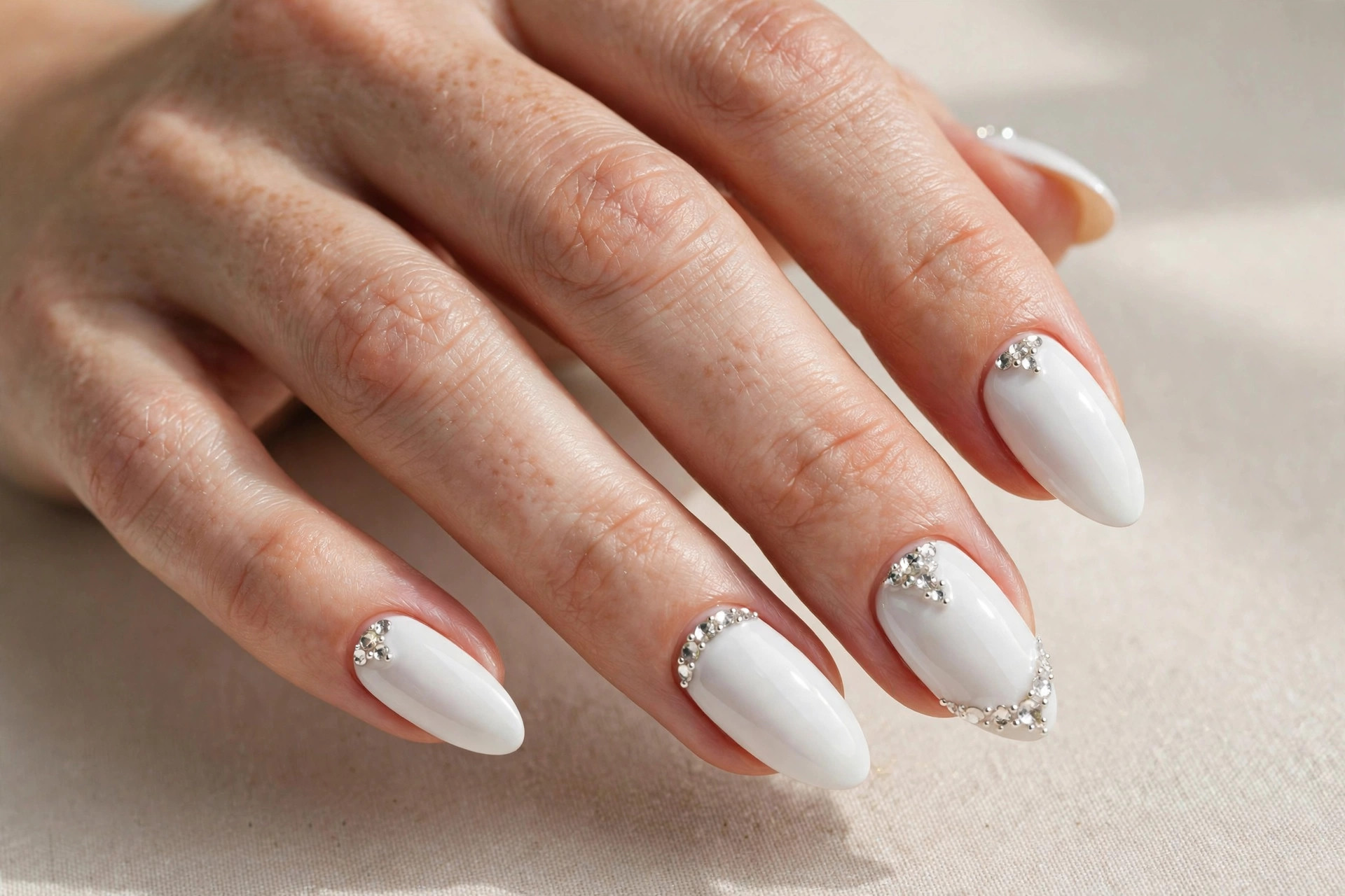 White nails with sparkling rhinestone accents