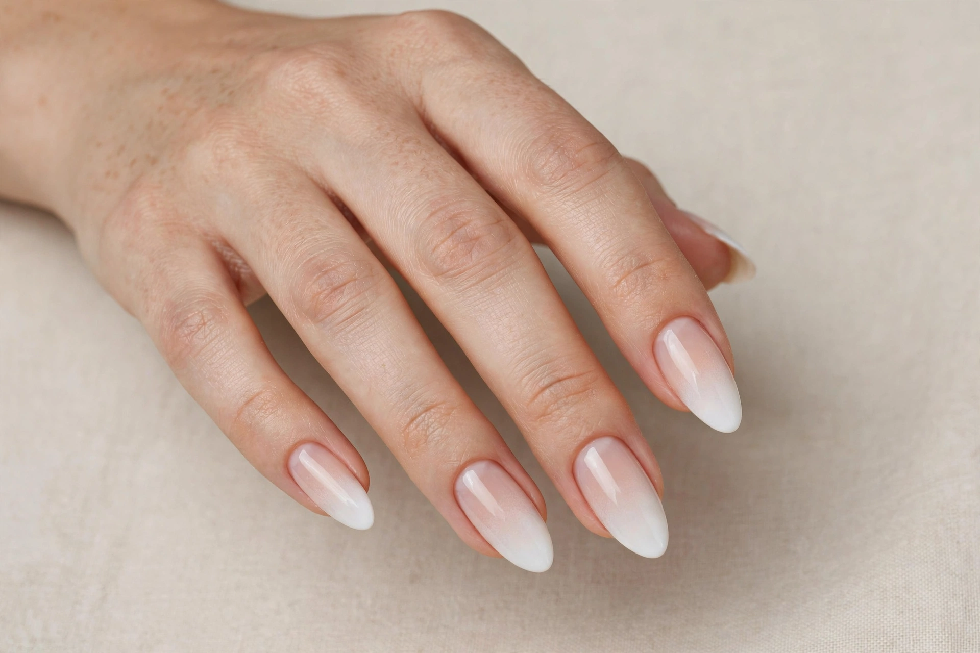 White ombre fade tip manicure blending into nude base