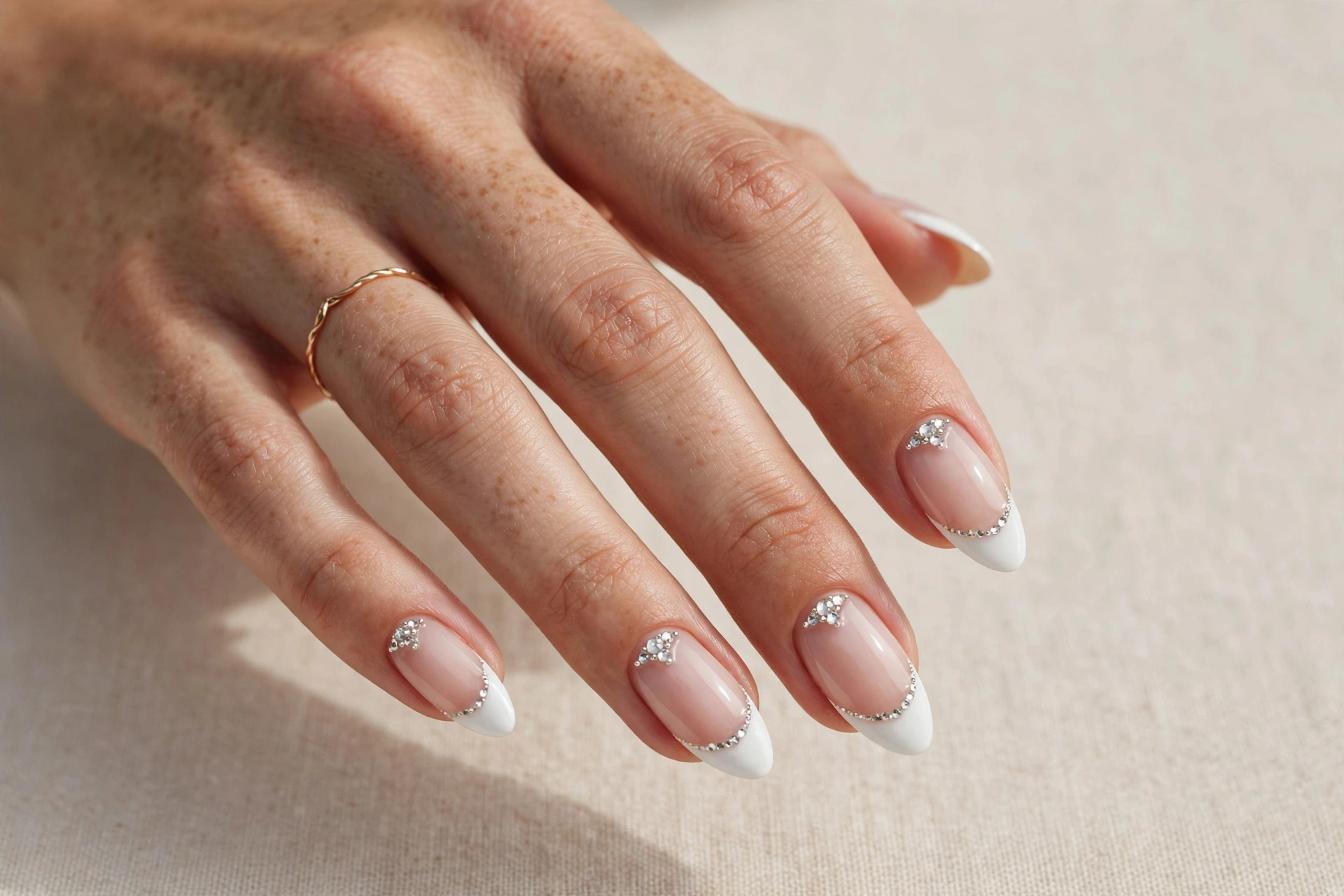 White tip nails with sparkling rhinestone accents