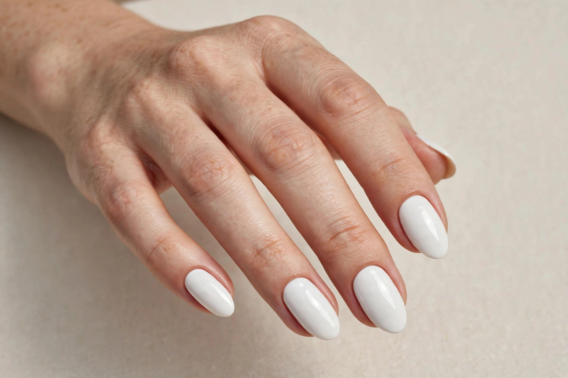 Almond nails with a simple glossy winter white manicure