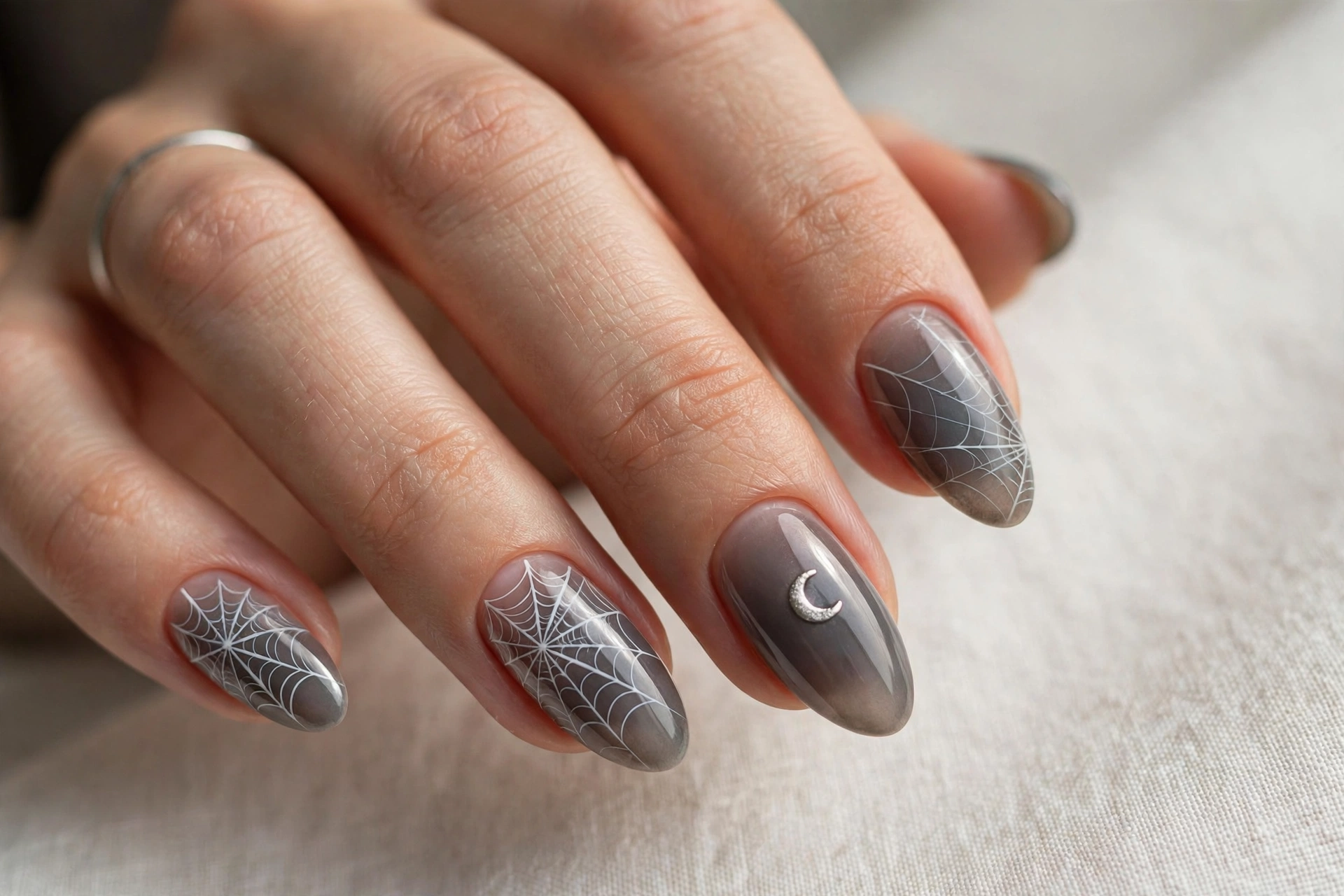 Smoky gray nails with delicate white spiderweb lines and a silver crescent moon